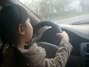 Perigo: menina sequer consegue girar o volante