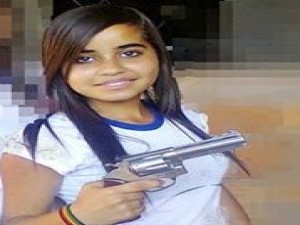 Estudante faz pose segurando um revólver