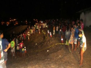 Polícia isola a área onde o corpo foi encontrado enquanto curiosos observam