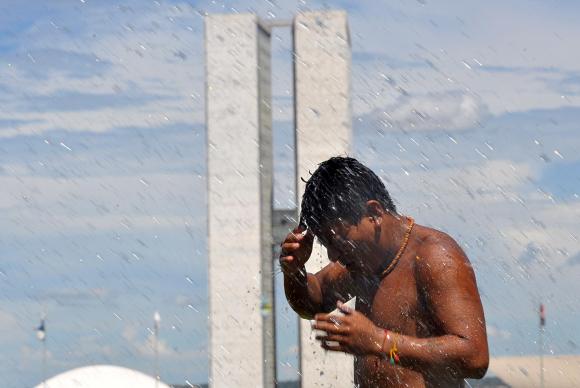 Para fugir do calor e da seca, homem molha o corpo na Esplanada dos Ministérios, em Brasília