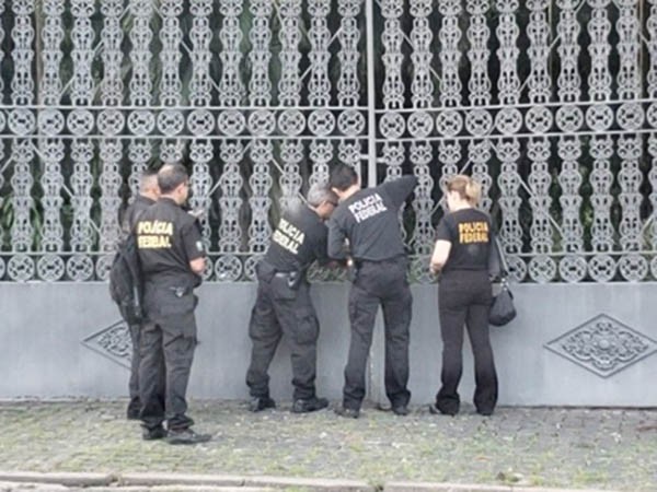 Policiais mfederais arrombam o portão da mansão