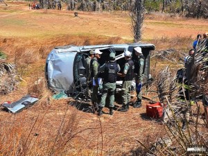 Curiosos observam o carro virado: três feridos