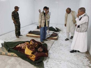 Moradores observam os corpos de Kadhafi, Muatassim e do chefe militar do antigo regime, nesta segunda-feira (24), em Misrata
