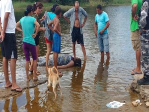 Curiosos observam o corpo de uma mulher vitima de afogamento em Barras