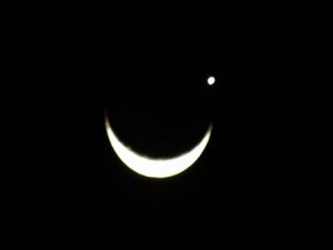 Imagem mostra o planeta como um ponto branco acima da lua