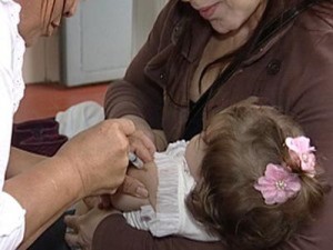 Criança recebe dose de vacina