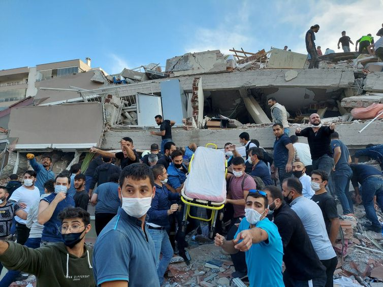 REUTERS/Tuncay Dersinlioglu/direitos reservados Moradores e oficiais procuram sobreviventes em um prédio desabado em Izmir