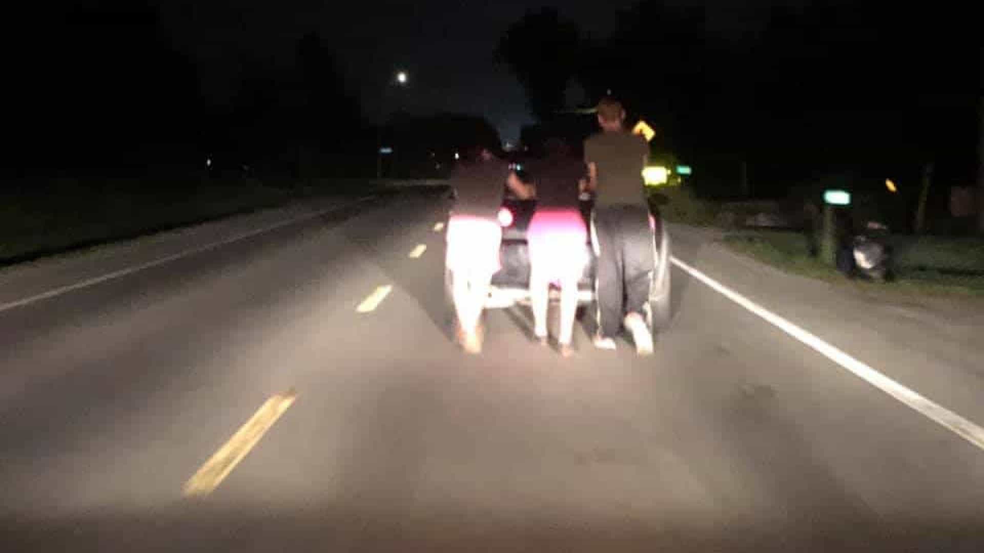 Jovens empurrando carro de mulher