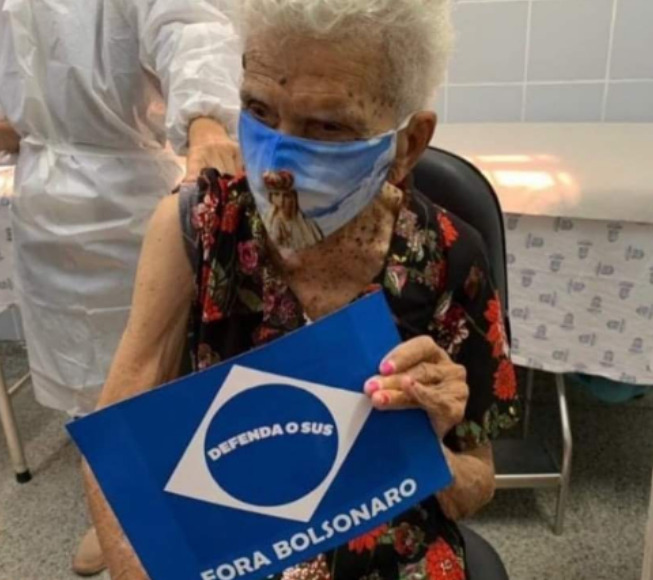 Idosa usou placa de protesto quando foi tomar a vacina