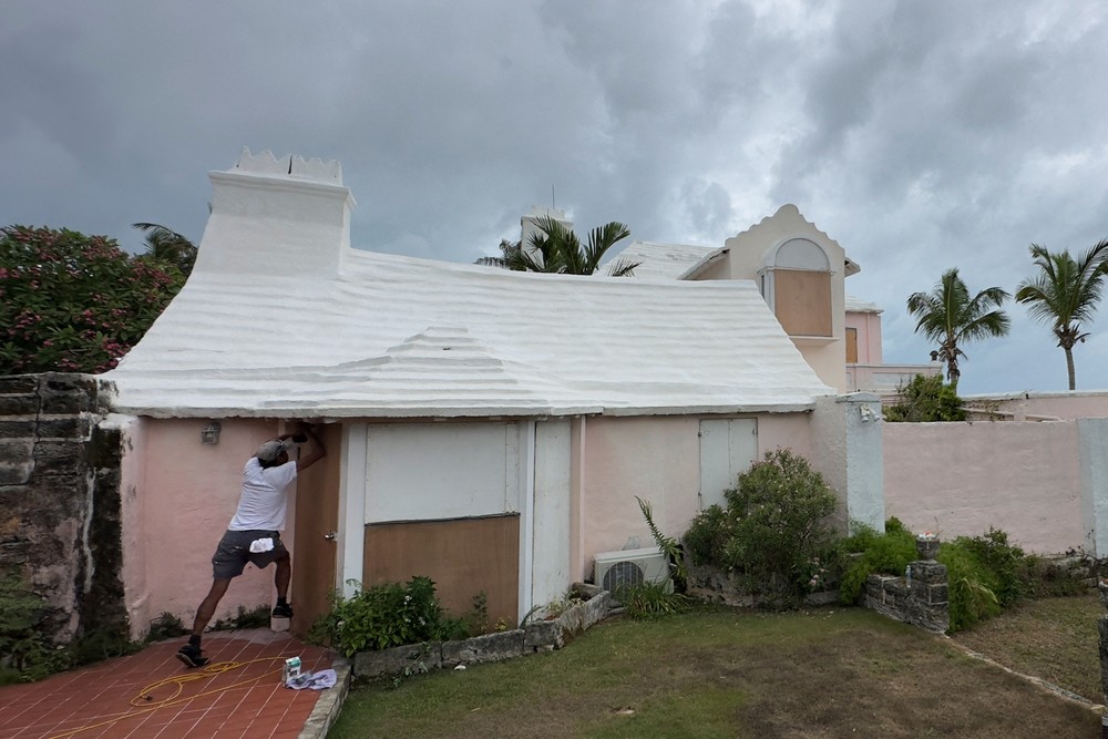 Homem tenta proteger casa do Furacão Ernesto em Warwick, Bermudas