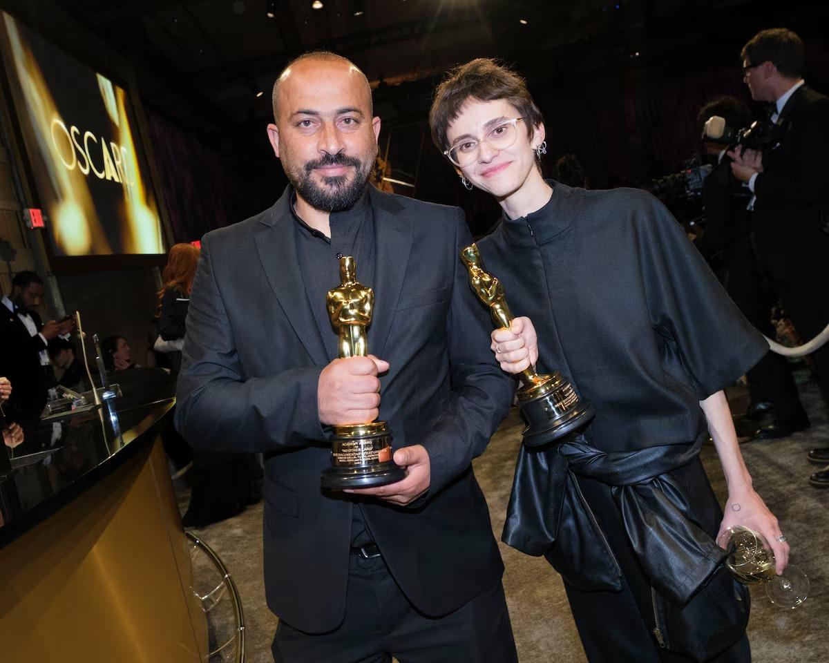 Os codiretores Hamdan Ballal e Rachel Szor posam com seus Oscars