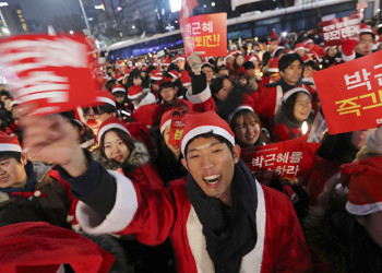 Jovens sul-coreanos protestam pela renúncia de presidente vestidos de Papai Noel