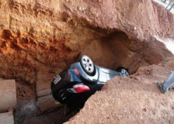 Motorista cai com carro em cratera
