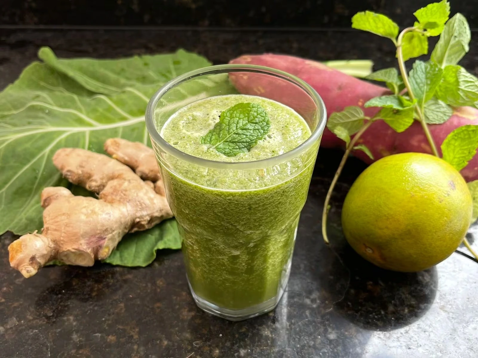 Suco verde preparado com couve, gengibre, batata-doce, laranja e hortelã