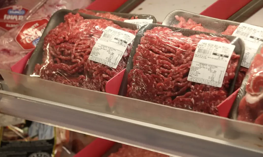Bandejas de carne moída expostas em prateleira refrigerada