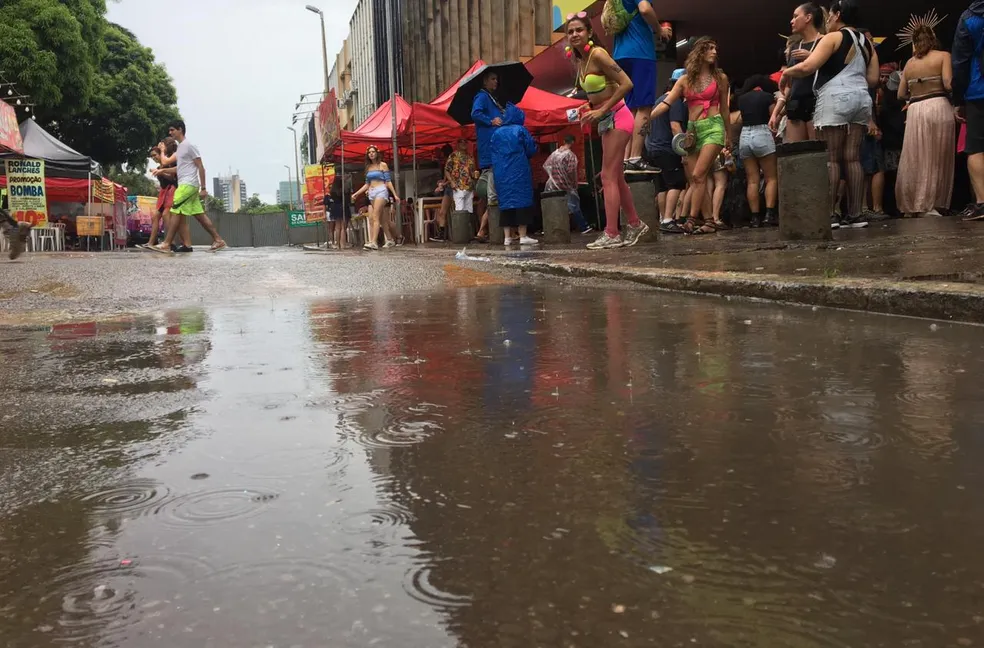 Foliões procuram marquise para se proteger da chuva no Carnaval de rua