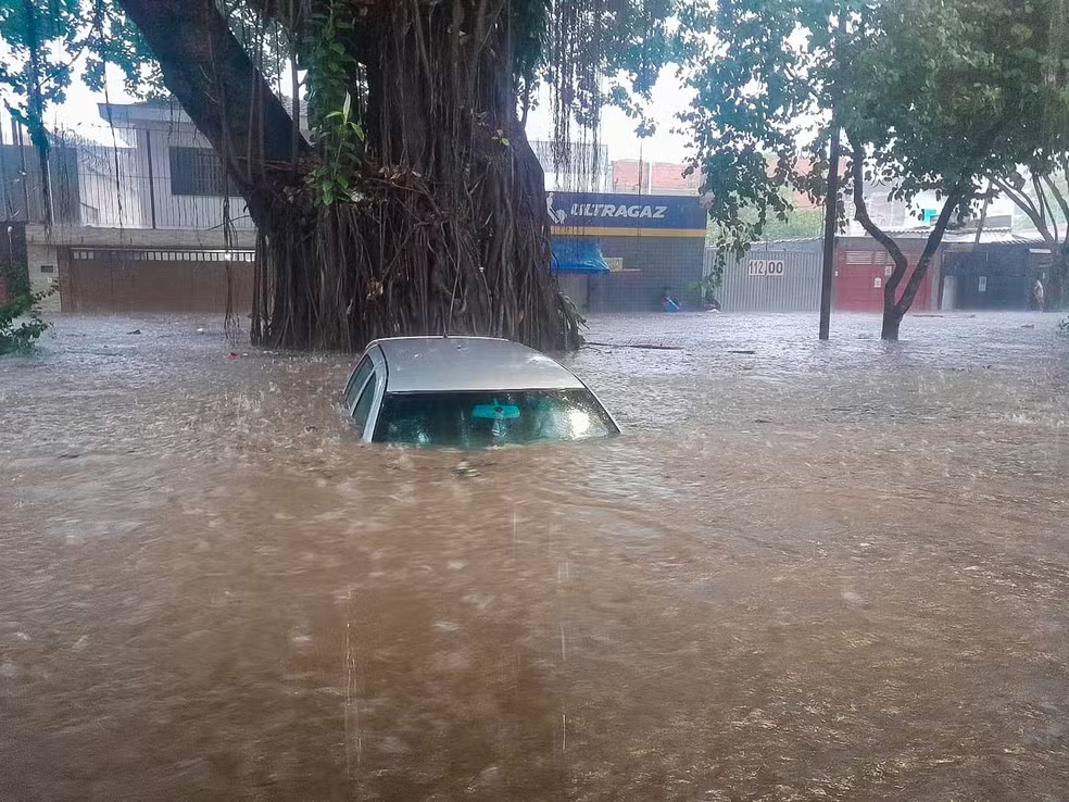 Carro fica submerso em alagamento em rua no bairro de Interlagos, na Zona Sul de São Paulo, após o temporal que atingiu a cidade na tarde deste sábado (23)