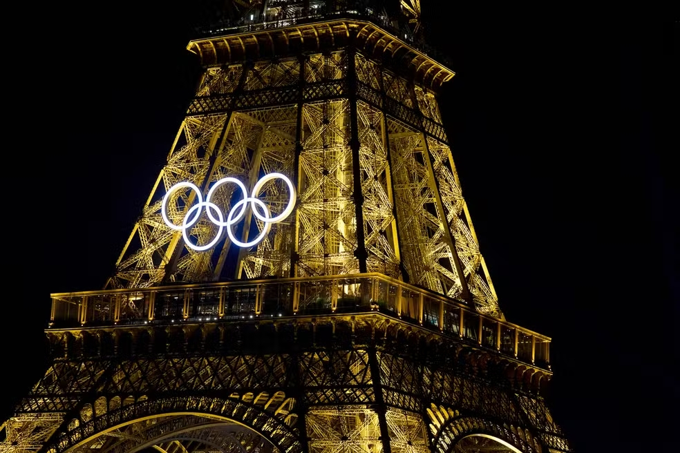 Torre Eiffel iluminada de noite com os anéis olímpicos