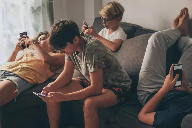 Adolescentes usando redes sociais em celulares