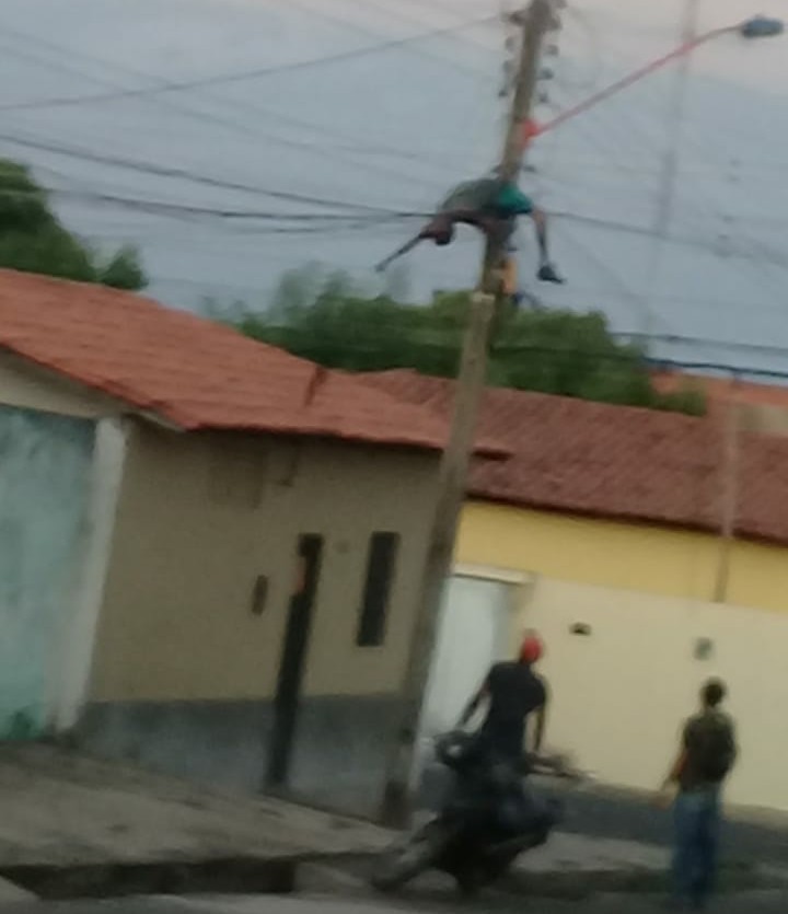 O homem aparece pendurado no poste e teria escapado