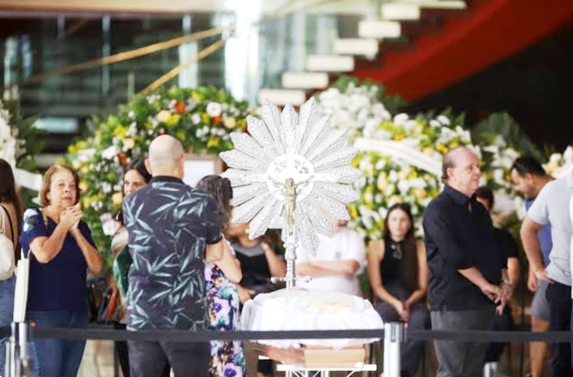 Caixão com corpo de Lô Borges coberto de flores