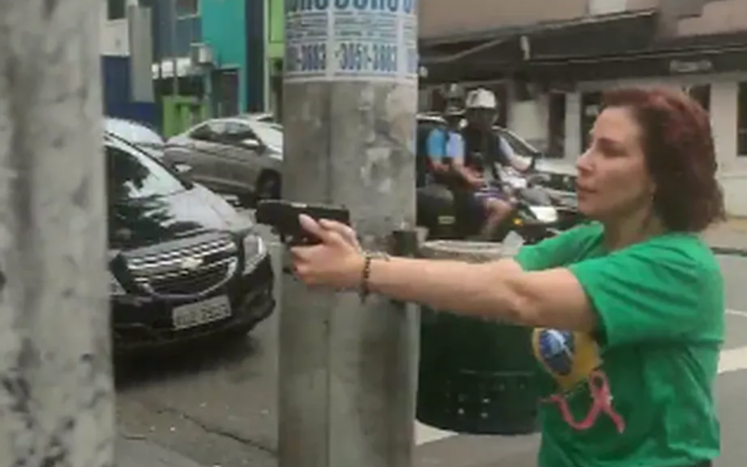 Carla Zambelli com arma apontada para militante do PT no meio da rua