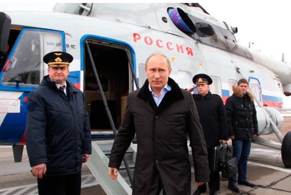 Vladimir Putin saindo do helicóptero presidencial rodeado de militares