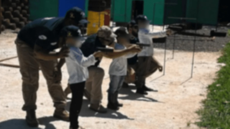 Crianças segurando armas de pressão em curso de tiros