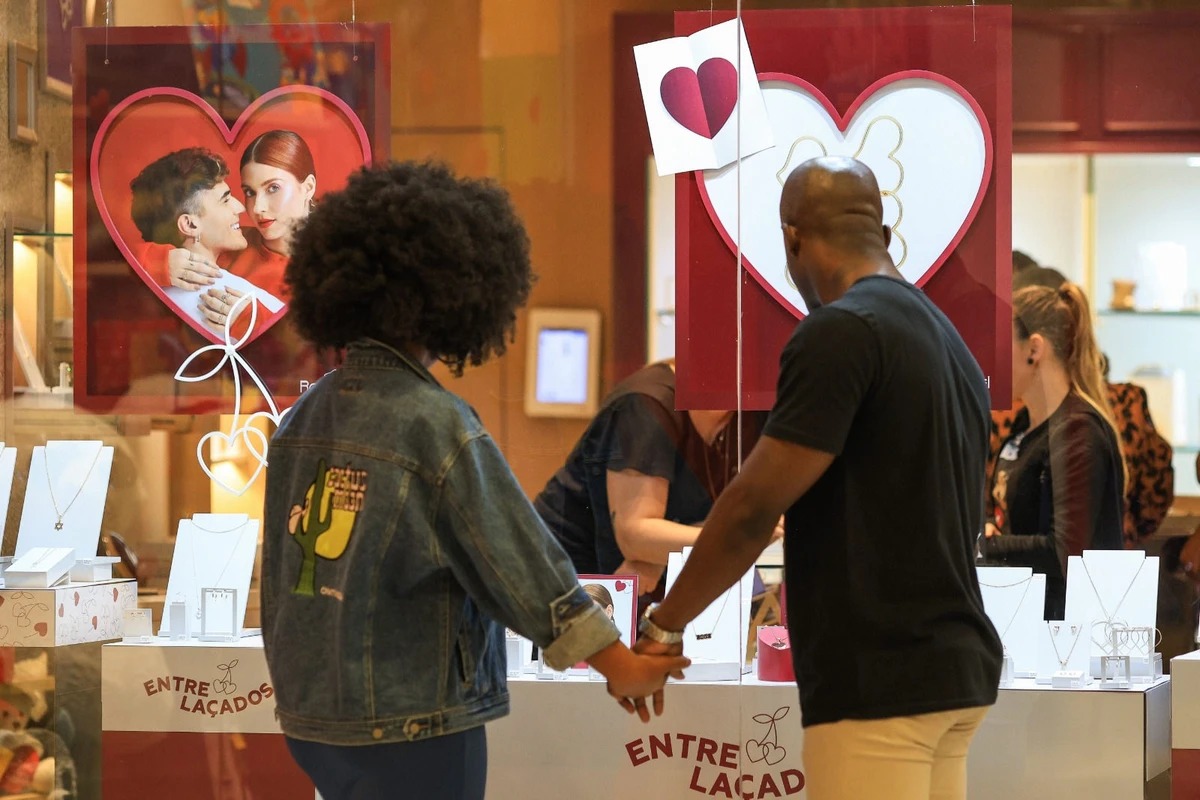 Casal observa produtos na vitrine de uma loja de shopping em Belo Horizonte