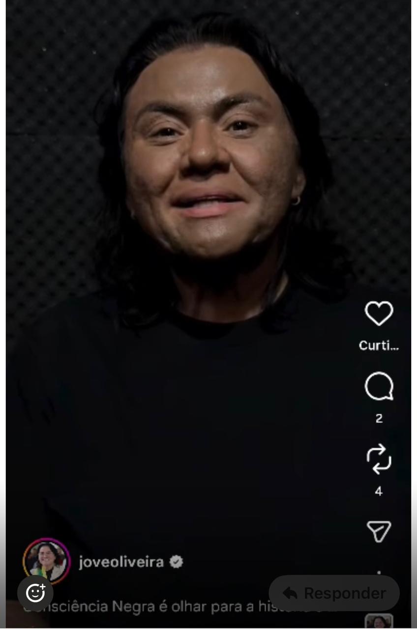 Jôve Oliveira aparece com o rosto artificialmente escurecido, recurso historicamente associado ao blackface