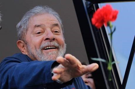 O ex-presidente Lula joga flores para apoiadores no RJ